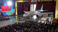 The C919 passenger plane is towed in front of an audience at Shanghai Aircraft Manufacturing on Monday. The plane is scheduled to lift off for its maiden voyage in 2016.