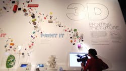 A woman films a 3D printing museum display A woman films a 3D printing museum display