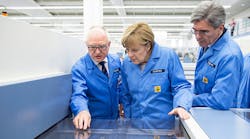 Professor Karl-Heinz B&uuml;ttner, left, the head of the Siemens plant in Amberg and company CEO Joe Kaeser, right, talk German Chancellor Angela Merkel through the process of printing a circuit board during her visit to the Siemens AG Electronics Manufacturing Plant.
