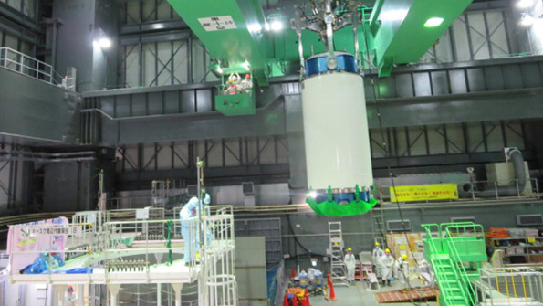 Workers operate a cask to remove nuclear fuel rods at No 4 reactor at Fukushima