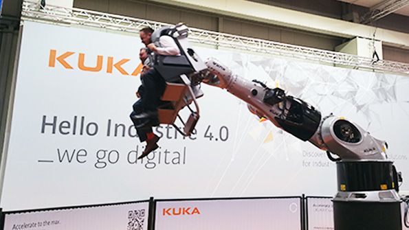 Hannover Messe attendees ride a roller coaster made from a Kuka industrial robot
