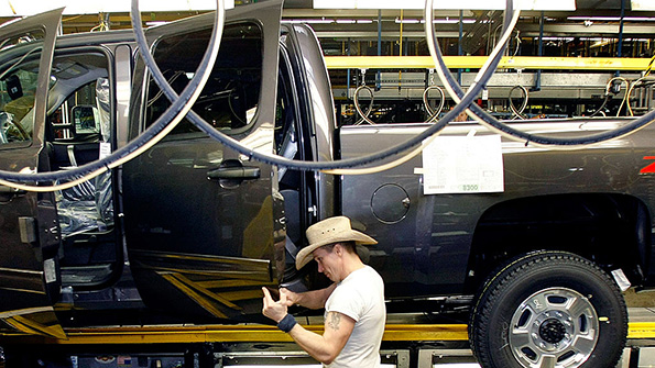 A GM worker checks doors at the Flint Michigan factory