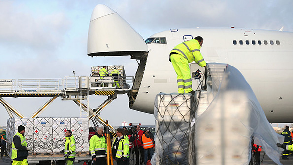 Airport workers load cargo through the nose of a Boeing 747
