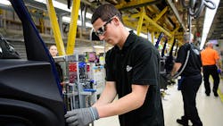 An assembly line employee at work on a Mini in Cowley England An assembly line employee at work on a Mini in Cowley England