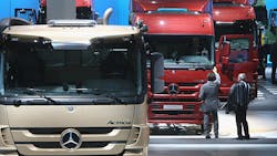 A row of Mercedes trucks at an industry event A row of Mercedes trucks at an industry event