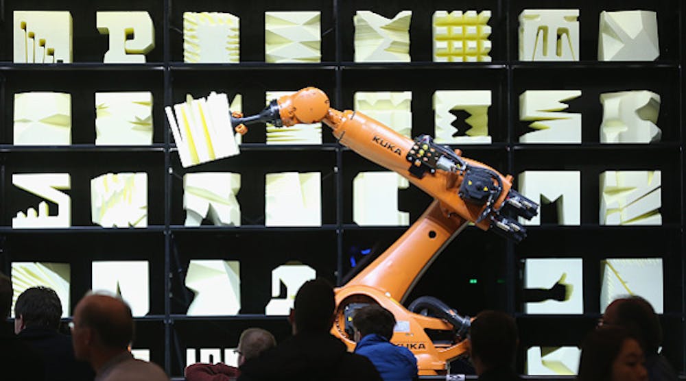 Visitors watch a Kuka robot perform precise movements as part of the Robochop interactive robot installation at the 2015 CeBIT technology trade fair in Hanover, Germany.