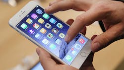 A user slides through the Apple iPhone 6 home screen A user slides through the Apple iPhone 6 home screen