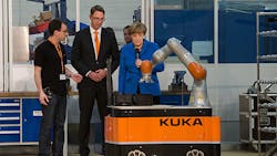 German Chancellor Angela Merkel studies a Kuka industrial robot at an inveiling German Chancellor Angela Merkel studies a Kuka industrial robot at an inveiling