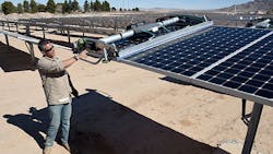SunPower field supervisor Oscar Madrigal demonstrates a panel-washing robot on a row of solar panels at the 102-acre, 15-megawatt Solar Array II Generating Station at Nellis Air Force Base in Las Vegas.