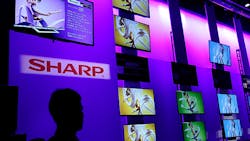 A CES attendee looks at the wall of screens in the Sharp booth A CES attendee looks at the wall of screens in the Sharp booth