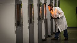 A Proto Labs employee checks product progress in 3D printers A Proto Labs employee checks product progress in 3D printers