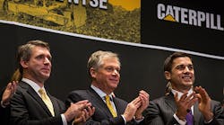 Caterpillar CEO Douglas Oberhelman, center, claps after ringing the opening bell in recognition of the company&rsquo;s 85th anniversary on the NYSE.