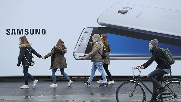 Germans walk and bike past a large ad for the Samsung Galaxy S7 phone