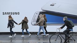 Germans walk and bike past a large ad for the Samsung Galaxy S7 phone Germans walk and bike past a large ad for the Samsung Galaxy S7 phone