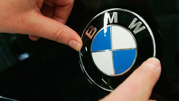 A BMW hood ornament logo is affixed to a new car