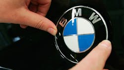 A BMW hood ornament logo is affixed to a new car A BMW hood ornament logo is affixed to a new car