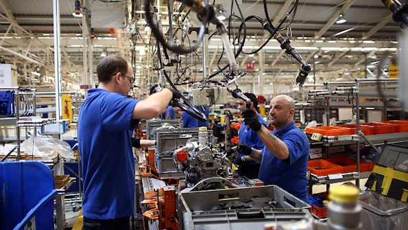 Employees work on an engine production line at a Ford factory in Dagenham England The plant employs around 3000