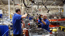 Employees work on an engine production line at a Ford factory in Dagenham England The plant employs around 3000