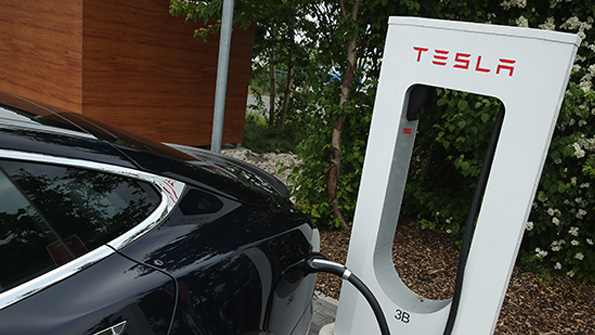 A Tesla charges at a public location