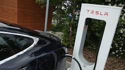 A Tesla charges at a public location A Tesla charges at a public location