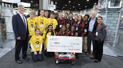 Blake Moret (left) and Jay Flores (right) of Rockwell Automation presented a ceremonial check for $12M to FIRST President Donald Bossi (second from right) and two FIRST Robotics teams at Automation Fair.