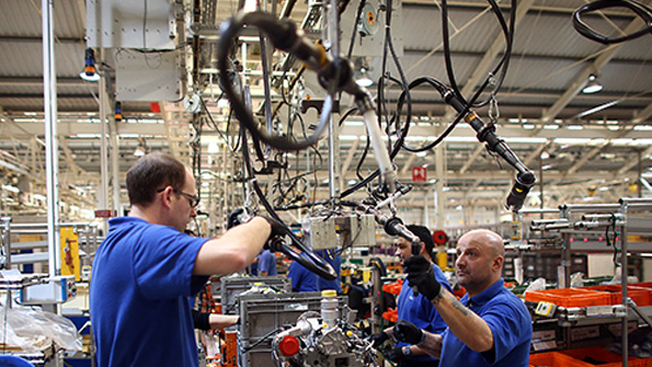 Ford plant employees work on an engine production line