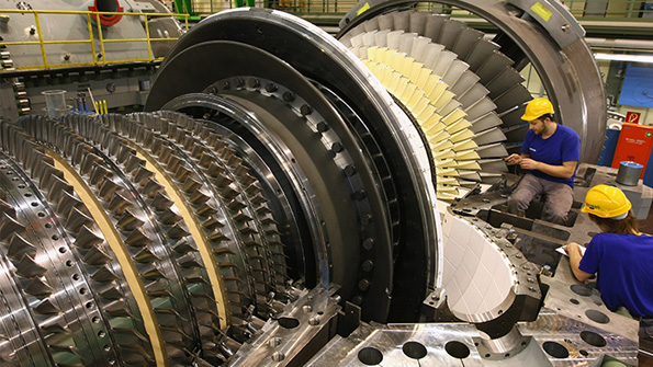 Workers assemble a gas turbine at a Siemens factory in Berlin