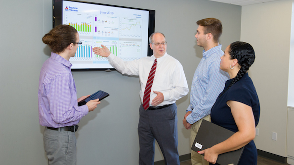 SherwinWilliams CIO Tom Lucas second from left talks with IT apprentices from left David Diemert Tyler Cronie and Daniella Pomales