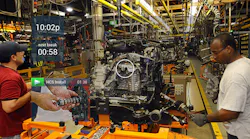 Workers assemble equipment while referencing a headsup display HUD