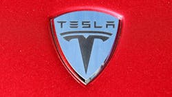 The Tesla logo on the hood of a car The Tesla logo on the hood of a car