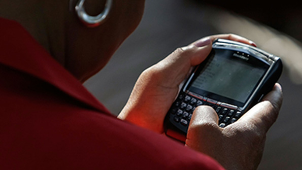 A woman holds a BlackBerry phone in 2008