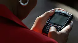 A woman holds a BlackBerry phone in 2008