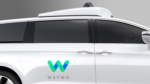 The Waymo logo on the side of a minivan