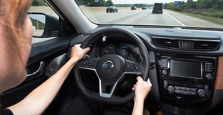 Woman with hands on steering wheel