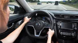 Woman with hands on steering wheel