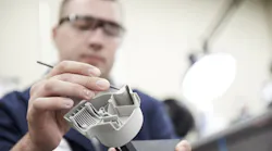 A worker designs a part for manufacturability.
