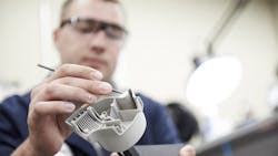 A worker designs a part for manufacturability. A worker designs a part for manufacturability.