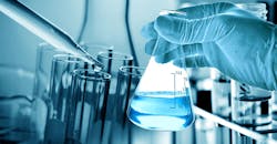 blue gloved hand holding flask with eyedropper blue gloved hand holding flask with eyedropper