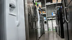A row of refrigerators inside a big box store.