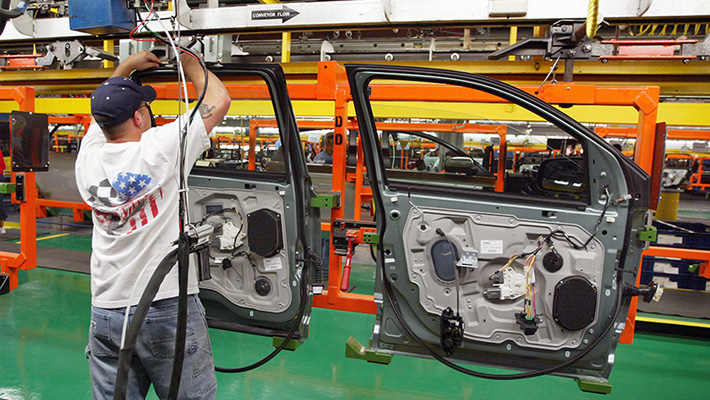 A worker assembles car doors at a Ford plant in Chicago.