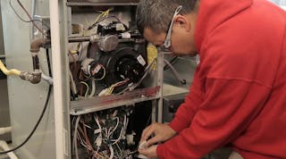 A Ranken Technical College student examines a Nidec motor.