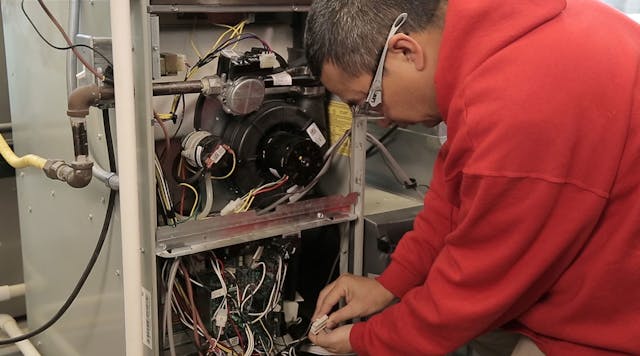 A Ranken Technical College student examines a Nidec motor.