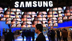 A wall of screens beneath a Samsung logo at a trade show. A wall of screens beneath a Samsung logo at a trade show.
