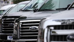 A row of Ford F-Series pickups on a lot. A row of Ford F-Series pickups on a lot.