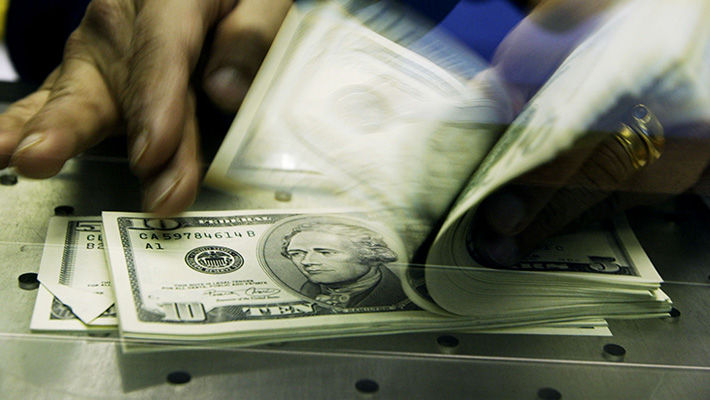 A stack of cash, mostly in $5 and $10 bills.