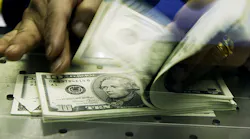 A stack of cash, mostly in $5 and $10 bills.