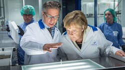 German chancellor Angela Merkel, right, visits a production facility for sterile glass vials at the Sanofi pharmaceuticals plants in Frankfurt.