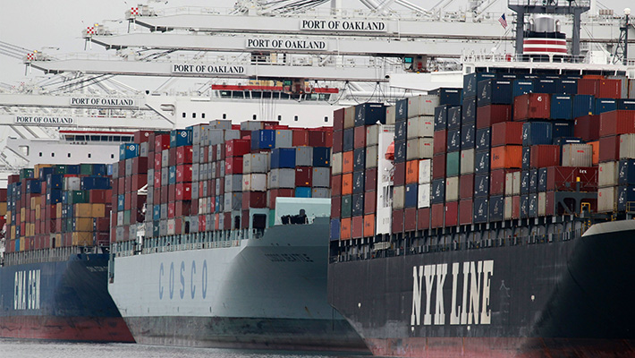 A fleet of container ships stand in the Port of Oakland.