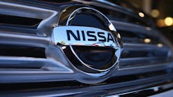 A Nissan logo on the front grille of a car. A Nissan logo on the front grille of a car.