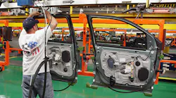 A line worker handles a door at a Ford plant.